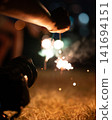person playing with handheld fireworks 141694151