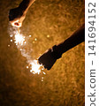 person playing with handheld fireworks 141694152