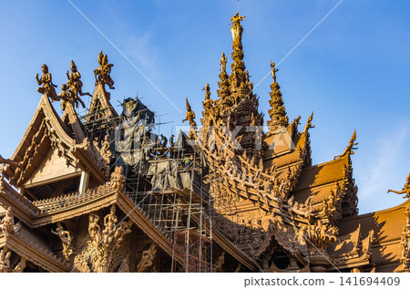 Sanctuary of Truth wooden temple carvings with restoration scaffolding in Pattaya, Thailand Sanctuary of Truth wooden temple carvings with restoration scaffolding in Pattaya, Thailand 141694409