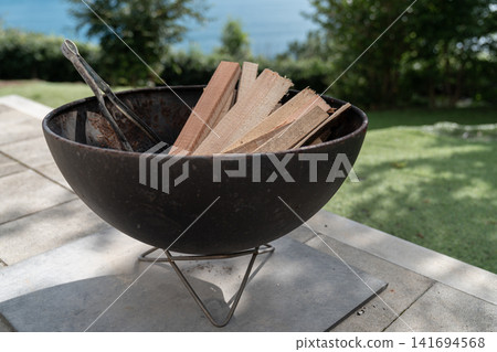 Fire pit, firewood, camping, outdoor, sea, ocean view, fire starting, barbecue, camping equipment Fire pit, firewood, camping, outdoor, sea, ocean view, fire starting, barbecue, camping equipment 141694568