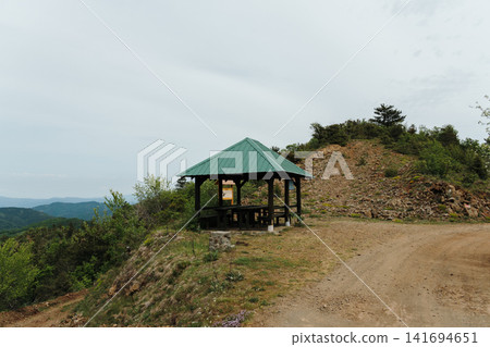 Small mountain shelter beside gravel road on Stolovi Mountain in Serbia during spring. Concept of hiking, travel rest and outdoor adventure Small mountain shelter beside gravel road on Stolovi Mountain in Serbia during spring. Concept of hiking, travel rest and outdoor adventure 141694651