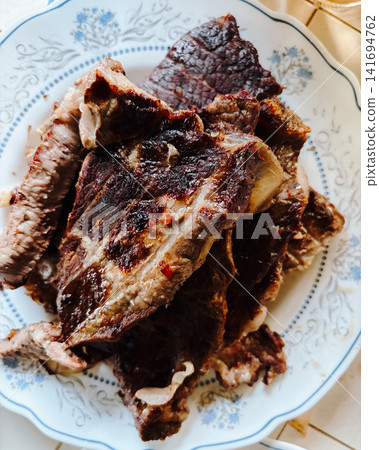 Roasted meat slices served on ceramic plate in warm natural light. Rustic homemade dinner concept for protein meal, traditional cooking and hearty comfort food Roasted meat slices served on ceramic plate in warm natural light. Rustic homemade dinner concept for protein meal, traditional cooking and hearty comfort food 141694762