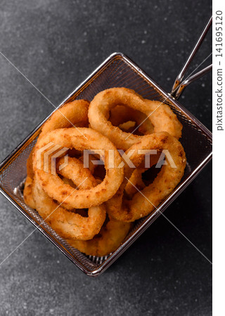Deep fried breaded onion or squid rings, crispy fast food snacks. Fried onion or squid rings Deep fried breaded onion or squid rings, crispy fast food snacks. Fried onion or squid rings 141695120