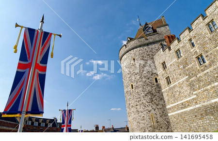 The Curfew Tower and historic stone ramparts at Windsor Castle decorated with Union Jack banners The Curfew Tower and historic stone ramparts at Windsor Castle decorated with Union Jack banners 141695458
