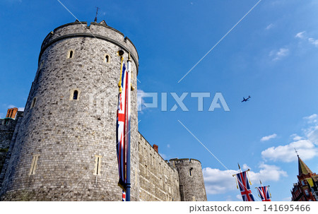 The medieval Curfew Tower at Windsor Castle under a bright blue sky with a passing airplane The medieval Curfew Tower at Windsor Castle under a bright blue sky with a passing airplane 141695466