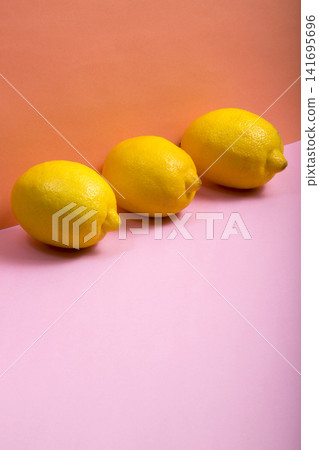 Three ripe yellow lemons on a colored background Three ripe yellow lemons on a colored background 141695696