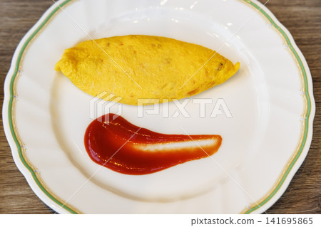 A plain omelet and ketchup served simply on a white plate. A plain omelet and ketchup served simply on a white plate. 141695865