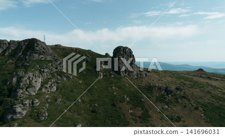 Rocky peaks of Babin Zub mountain in Stara Planina National Park, Serbia, rise above green forests under a blue sky. Aerial view from drone Rocky peaks of Babin Zub mountain in Stara Planina National Park, Serbia, rise above green forests under a blue sky. Aerial view from drone 141696031