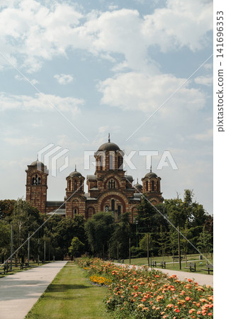 Saint Mark's Church rises above the trees in Tasmajdan Park in Belgrade, Serbia. Historic Orthodox architecture surrounded by lush greenery in a peaceful urban setting Saint Mark's Church rises above the trees in Tasmajdan Park in Belgrade, Serbia. Historic Orthodox architecture surrounded by lush greenery in a peaceful urban setting 141696353
