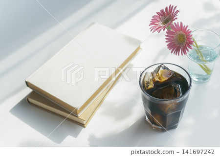 夏日閱讀時光,配上冰咖啡、書籍和粉紅色的非洲菊。 夏日閱讀時光,配上冰咖啡、書籍和粉紅色的非洲菊。 141697242
