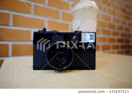 Vintage black film camera on wooden table Vintage black film camera on wooden table 141697523