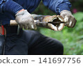 Man splitting bamboo 141697756