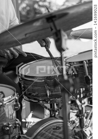 Black and white close-up photo of a drummer playing snare with wire brushes Black and white close-up photo of a drummer playing snare with wire brushes 141699028