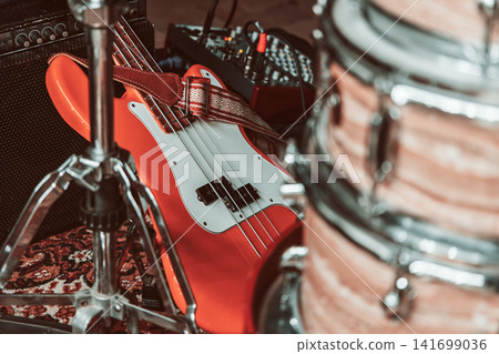 Red electric bass and drum kit equipment in a moody vintage color treatment Red electric bass and drum kit equipment in a moody vintage color treatment 141699036