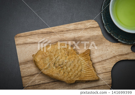 享用美味的鯛魚燒配茶。 享用美味的鯛魚燒配茶。 141699399