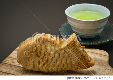 享用美味的鯛魚燒配茶。 享用美味的鯛魚燒配茶。 141699406