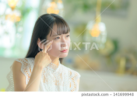 一位女子用手指揉搓著眼睛。 141699948