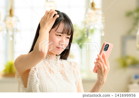一名女子正在擺弄她的智慧型手機。 141699956