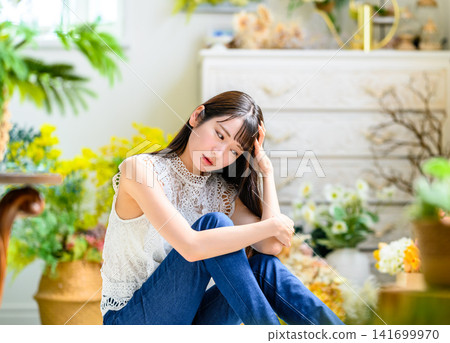 一位年輕女子在房間裡陷入沉思。 141699970