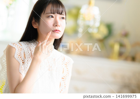 一個女人用手指撫摸自己的臉 141699975