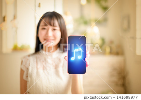 一位女士正在用智慧型手機聽音樂。 141699977