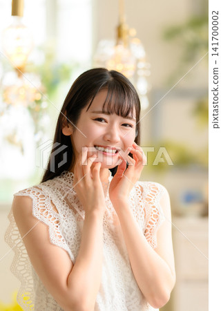 一位面帶微笑的女子,身穿白色蕾絲洋裝。 一位面帶微笑的女子,身穿白色蕾絲洋裝。 141700002
