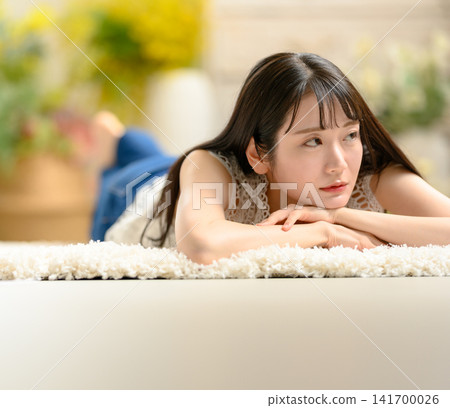 一位女士正躺在地毯上放鬆。 141700026