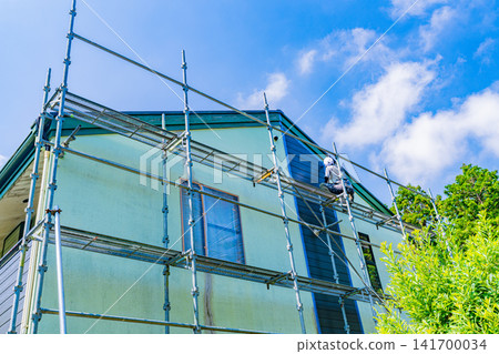 在炎炎夏日裡對房屋外牆進行修繕和粉刷工作。 在炎炎夏日裡對房屋外牆進行修繕和粉刷工作。 141700034