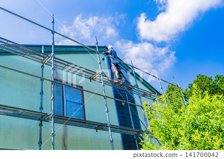 在炎炎夏日裡對房屋外牆進行修繕和粉刷工作。 在炎炎夏日裡對房屋外牆進行修繕和粉刷工作。 141700042