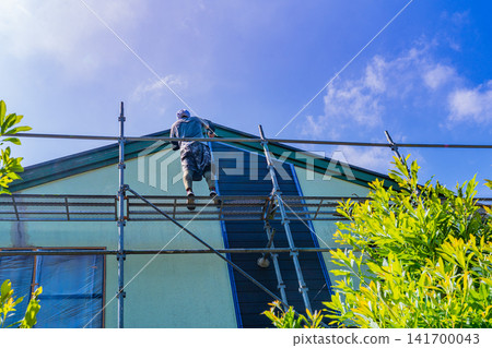 Repair and painting work on the exterior walls of houses in the scorching summer sun. Repair and painting work on the exterior walls of houses in the scorching summer sun. 141700043