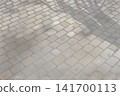 Background material of cobblestones with shadows cast by sunlight filtering through trees 141700113