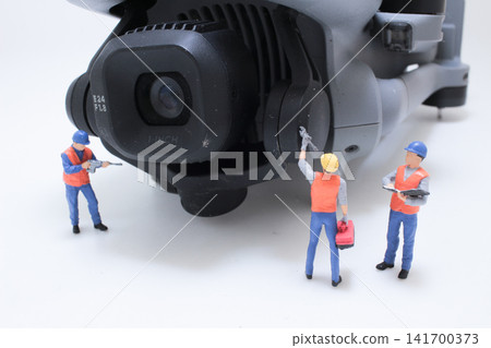 Miniature technicians servicing drone camera gimbal Miniature technicians servicing drone camera gimbal 141700373
