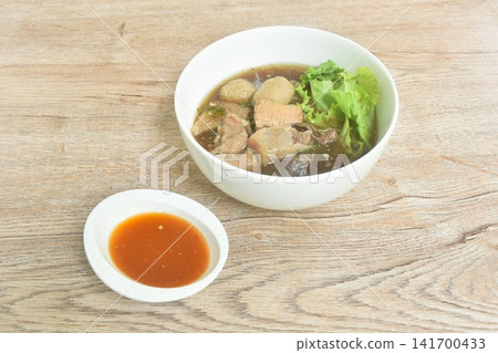 boiled braised beef meat and tendon couple organ in herb brown soup oncircle bowl dipping spicy chili sauce boiled braised beef meat and tendon couple organ in herb brown soup oncircle bowl dipping spicy chili sauce 141700433