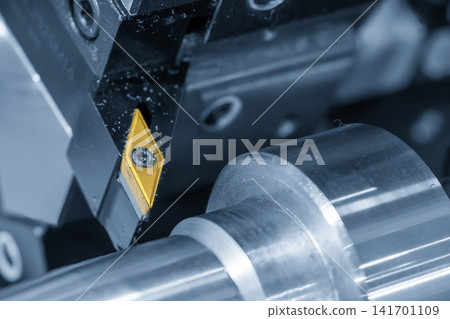 Close up of indexable carbide insert tool on CNC lathe machine in blue tone lighting. Close up of indexable carbide insert tool on CNC lathe machine in blue tone lighting. 141701109
