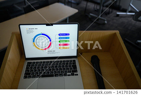 講台上放著筆記型電腦、麥克風和簡報資料。 講台上放著筆記型電腦、麥克風和簡報資料。 141701626