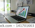 Growth graph and documents displayed on a laptop 141701663