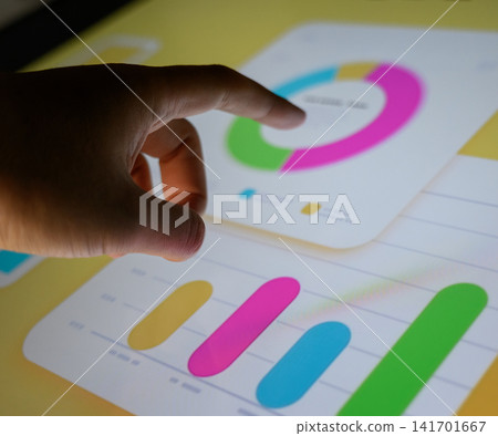 A business person's hand manipulating pie chart data on a touch panel. A business person's hand manipulating pie chart data on a touch panel. 141701667