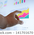 A businessman checking a line graph with his finger. 141701670