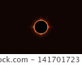 A dramatic total solar eclipse captured against a dark background, featuring the Moon completely covering the Sun and creating a brilliant glowing corona. 141701723
