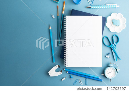 Creative workspace arrangement with art supplies and stationery on blue background Creative workspace arrangement with art supplies and stationery on blue background 141702397