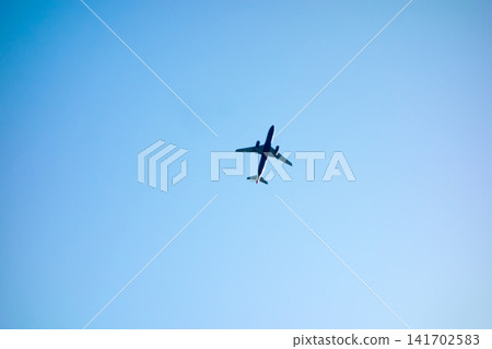 一架客機飛越湛藍的天空。 一架客機飛越湛藍的天空。 141702583