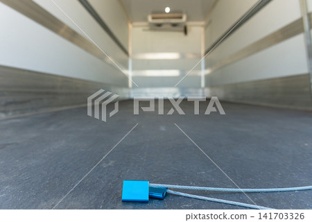 Blue plastic security seal locking an empty commercial truck cargo bed 141703326