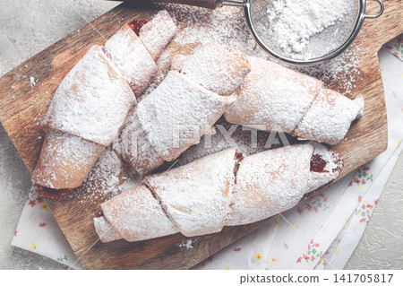 bagels with filling, sweet pastries, sprinkled with powdered sugar, on a wooden board, dessert, breakfast, bagels with filling, sweet pastries, sprinkled with powdered sugar, on a wooden board, dessert, breakfast, 141705817