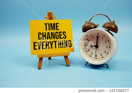 Time Changes Everything text with alarm clock on blue background Time Changes Everything text with alarm clock on blue background 141706077