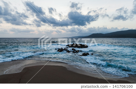 Landscape of Propriano beach of Corsica island. A picturesque shoreline with dark rocks Landscape of Propriano beach of Corsica island. A picturesque shoreline with dark rocks 141706100