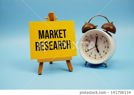 Market Research text written on paper card and alarm clock on blue background Market Research text written on paper card and alarm clock on blue background 141706134