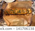 Sliced garlic baguette with fresh dill baked on parchment paper 141706138
