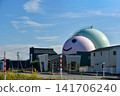 A landscape of gas tanks and a blue sky. 141706240