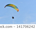 A powered paraglider flying in the blue sky along the Sea of Japan coast. 141706242