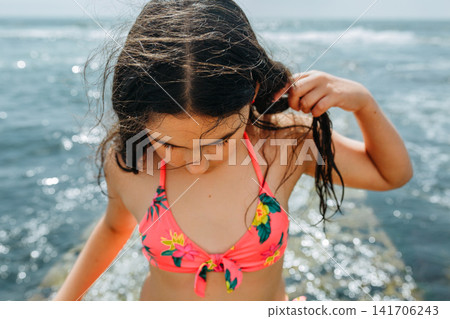 Thoughtful Young Girl Standing by the Sea During Summer Vacation Thoughtful Young Girl Standing by the Sea During Summer Vacation 141706243